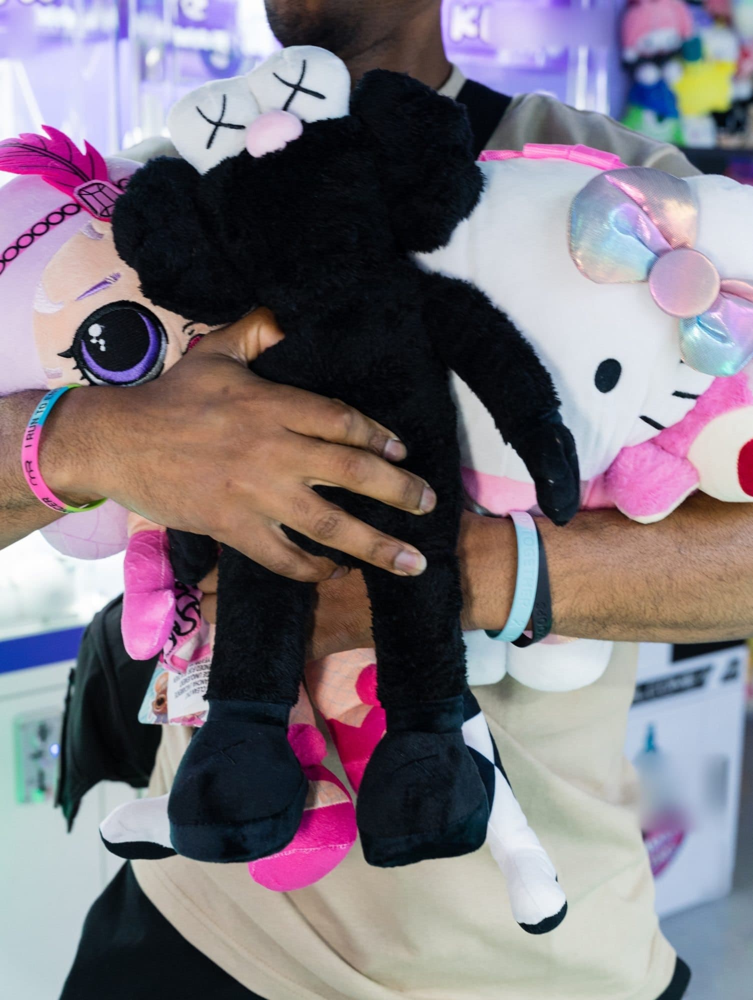 A guest hugging a big armful of plush prizes.