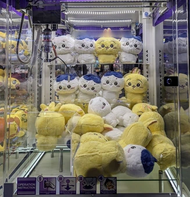 A claw machine packed to the glass with assorted plush toys.